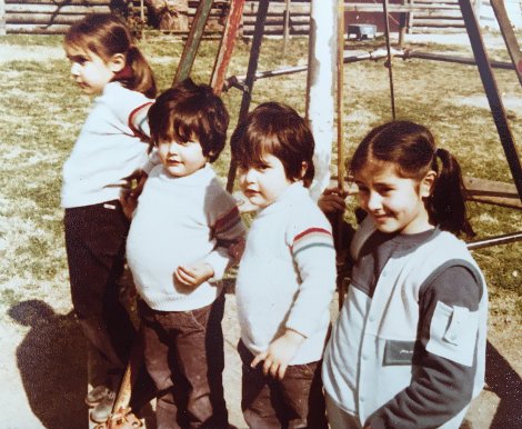 Four Locatelli children, three wearing similar hand knit sweaters
